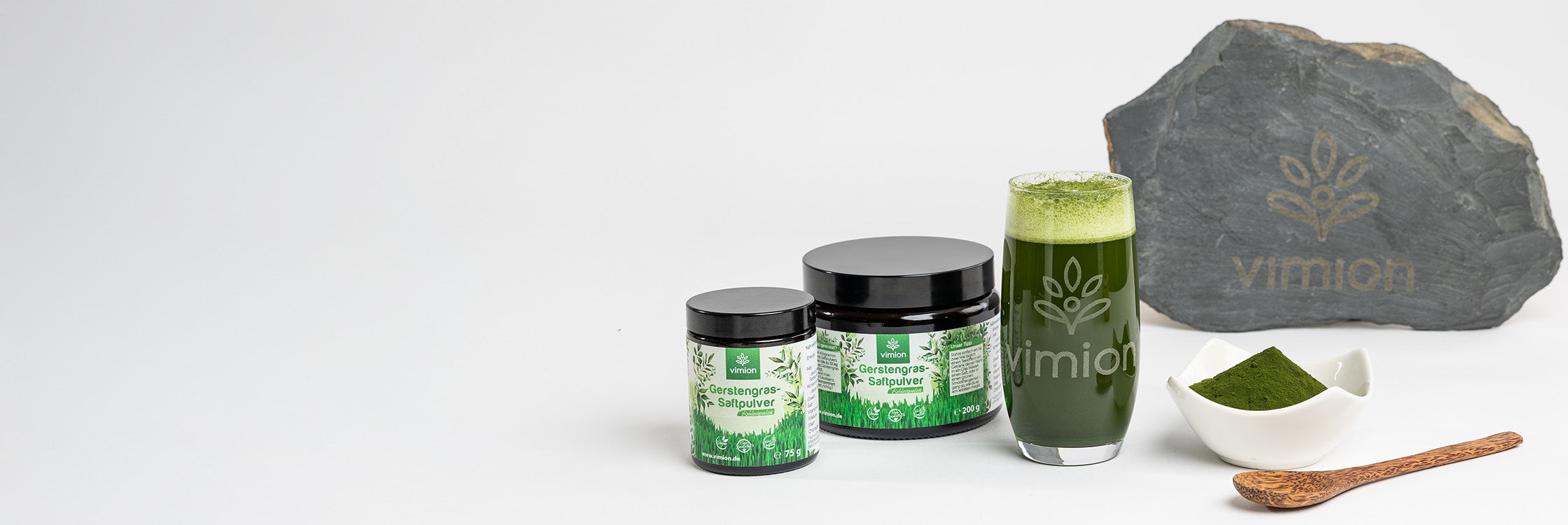 Vimion Gerstengrassaftpulver – vegane Produkte, Glas mit Saft, Pulver und Stein mit Logo